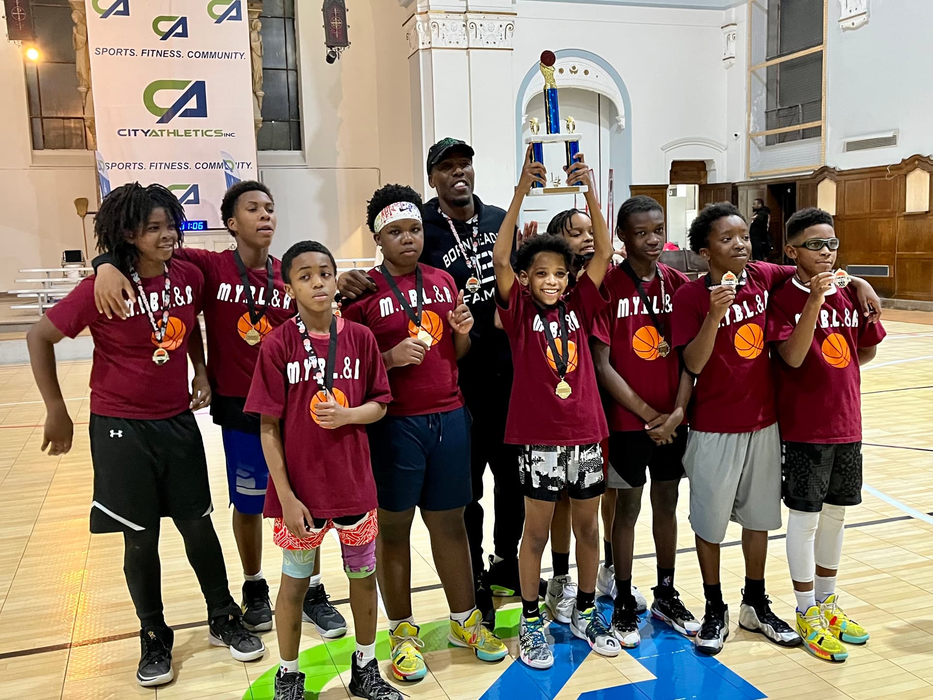 Born Leader Family team holding championship trophy and medals at City Athletics
