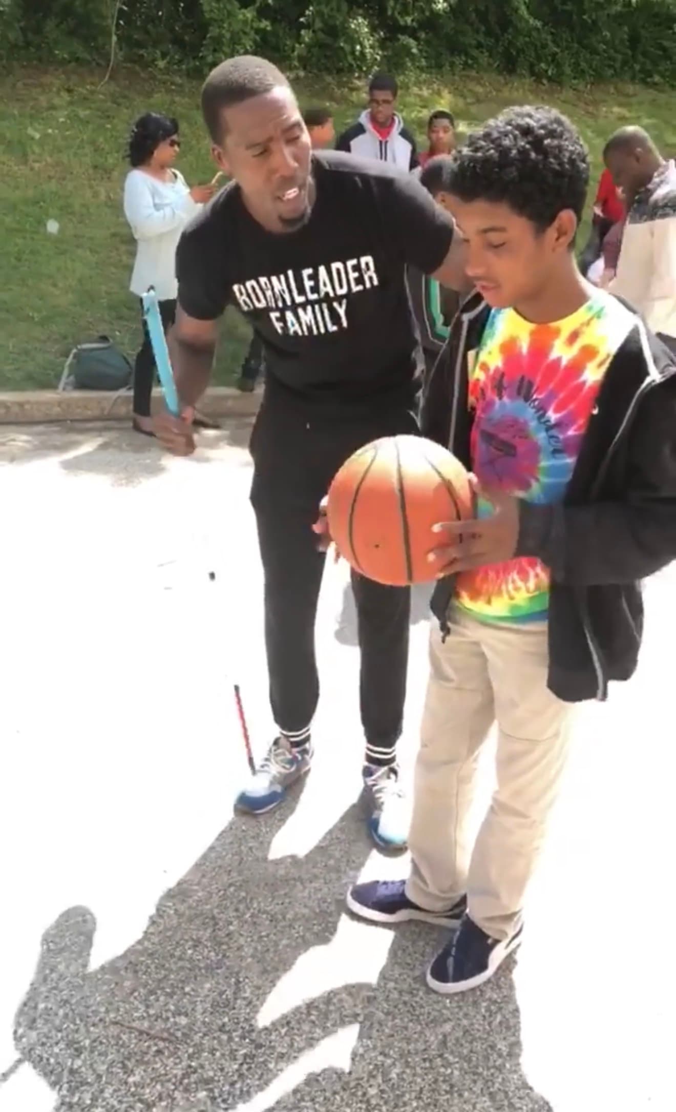 Tasheed coaching a teen in a tie-dye shirt at the special needs basketball clinic