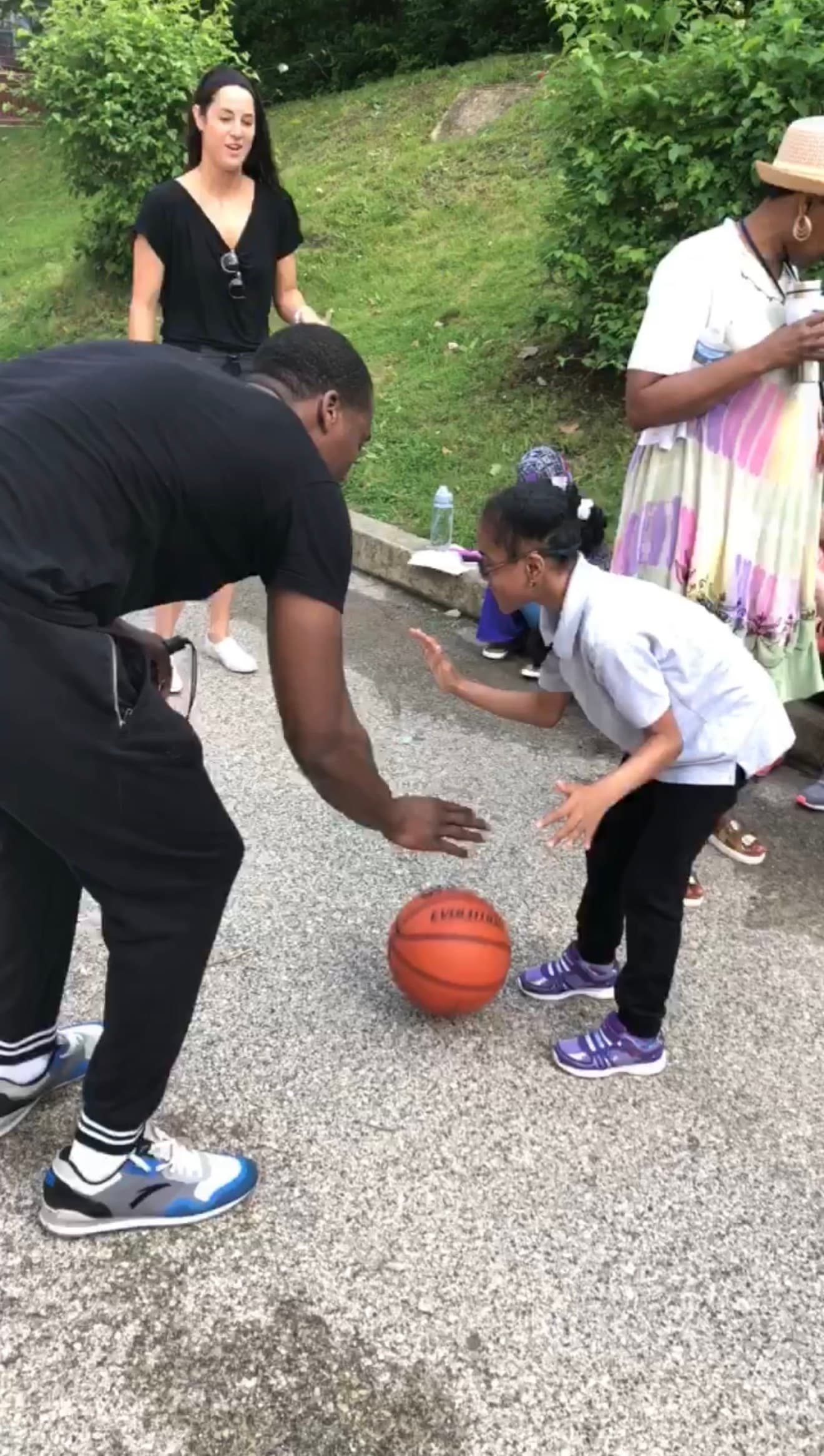 Young girl with special needs playing basketball with Tasheed Carr